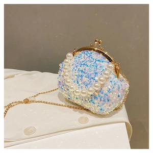 Macro detail of iridescent sequins and faux pearl handle on a retro clasp handbag