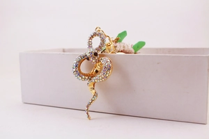 Close-up of golden metal snake keychain adorned with sparkling colorful rhinestones
