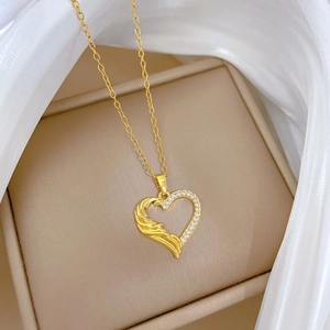 Elegant gold titanium steel heart necklace with cubic zirconia on a soft cloth