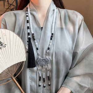 Long beaded necklace with Ruyi lock pendant and tassel on model in neo-Chinese style
