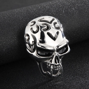 Macro detail of vintage silver skull ring with intricate punk engraving and high gloss finish