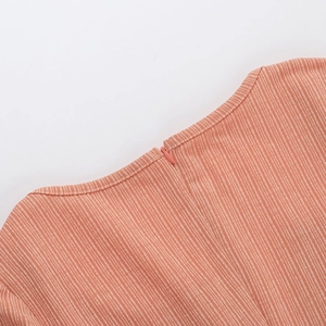Dettaglio dello scollo a V e della cerniera nascosta su vestito a coste arancione slim fit