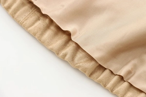 Macro detail of the beige suede jacket showing ribbed knit hem and smooth inner lining texture
