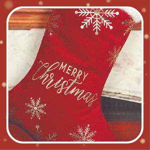 Close-up of red Christmas stocking with gold foil snowflakes and Merry Christmas script