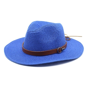 Detail of blue straw Panama hat featuring brown leather band and silver metal ring buckle