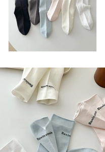 Detail of soft cotton socks with elegant letter embroidery in diverse pastel colors