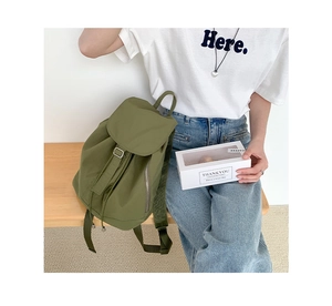 Zaino in nylon verde oliva con chiusura a coulisse e patta in una scena lifestyle