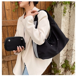 Detail view of black nylon shoulder bag with striped strap and matching coin purse