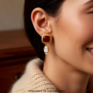Vintage gold square earrings with dark red gemstone and irregular pearl on female model