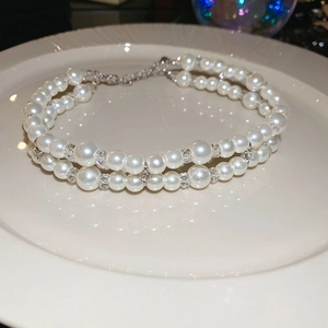 Detail of double-layer pearl choker showing glossy beads and silver lobster clasp closure