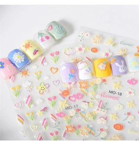 Close-up of 5D embossed nail stickers featuring colorful flowers, rabbits and rainbows