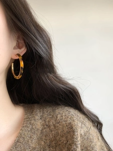 Side view of tortoise shell resin hoop earrings worn by a model for size and style