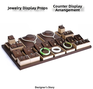 Detailed view of dark brown leather jewelry display set with ivory pedestals and stands