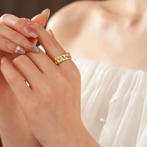 Detail view of 18k gold plated ring with linked hearts and crystal pave on a model finger