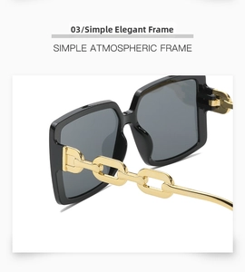Detail of square black sunglasses featuring elegant gold metal chain link temples