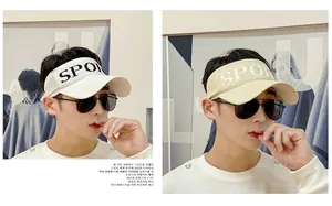 Detail of knitted sun visor hats in white and beige with black Sport lettering side print