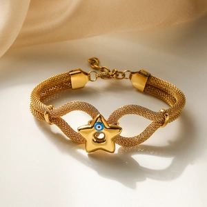 Golden woven mesh bracelet featuring a blue evil eye star pendant on beige background
