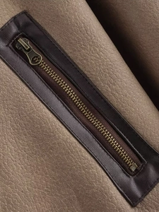Detail of vintage faux leather jacket featuring a bronze zipper and pebbled texture