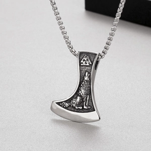 Vue détaillée du pendentif hache viking en acier avec relief loup et chaîne maille