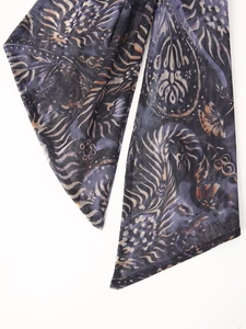 Détail du tissu en tulle bleu foncé avec des motifs floraux paisley dorés élégants