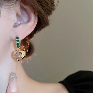 Vintage heart earrings with green zircons and pink gemstones on model
