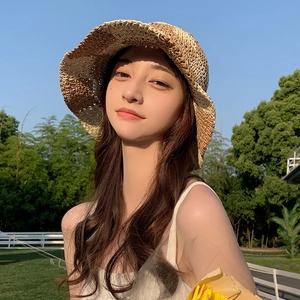 Handwoven straw bucket hat with plaid pattern in a sunny outdoor summer setting