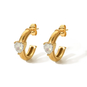 Detail of 18k gold plated C-shaped earrings featuring a heart-shaped zircon stone inlay