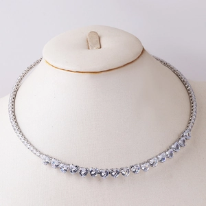 Detailed close-up of a silver tennis necklace with heart-shaped cubic zirconia on a mannequin