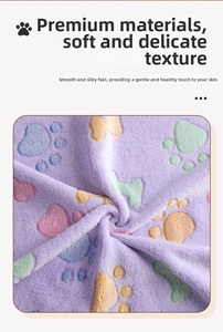 Macro shot of ultra-soft purple coral fleece pet blanket with colorful paw and bone patterns
