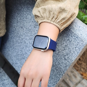 Blue silicone wave ocean strap for Apple Watch with gold case on a wrist outdoors