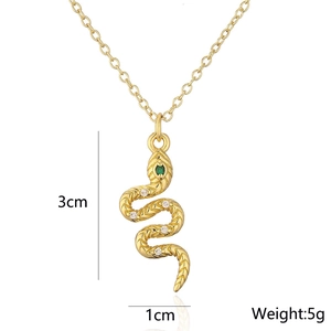 Detailed close-up of 18K gold snake pendant necklace with zircon and green gemstone eyes