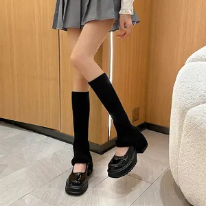 Chic black knitted leg warmers styled with platform Mary Jane shoes for a Y2K look