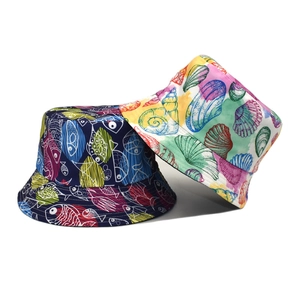 Reversible bucket hats with navy fish and colorful shell prints for sun protection