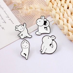 Set of four cartoon rabbit enamel pins showing yoga poses and ballet dancer movements