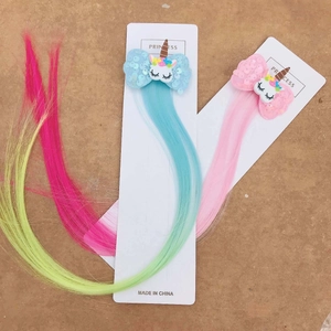 Detail of sequin bow hair clips with unicorn charms and colorful long wig extensions
