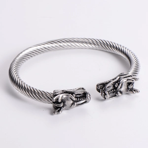 Detail of silver twisted cable bracelet with intricately carved double dragon heads