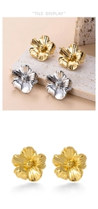 Detailed view of vintage metallic flower earrings with gold and silver radial textures