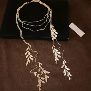 Elegant gold multi-layered leaf pendant necklace featuring long delicate tassel chains