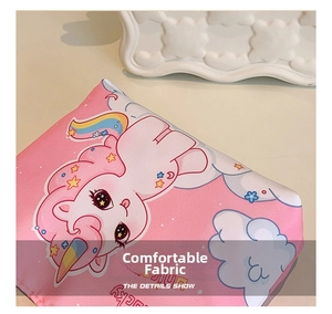 Close-up of pink fabric featuring lucky unicorn prints and rainbow stars pattern