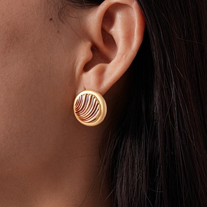Detail shot of vintage matte gold geometric round stud earring with radial textured patterns