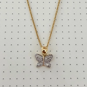 Detail of butterfly pendant necklace with cubic zirconia paving and two-tone gold finish