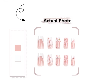 Detail of pink gradient press-on nails featuring 3D white bows, pearls, and floral art