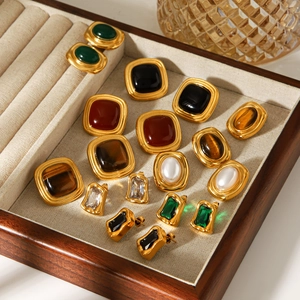 Vintage French style gold earrings with colorful stones and pearls in a display tray