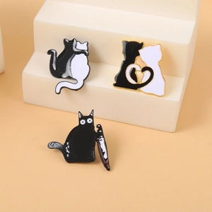 Cute black and white cat enamel pins featuring heart-shaped tails and a funny knife meme design