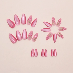 Detail showing pink cat-eye press-on nails with 3D cherry designs in long almond shape