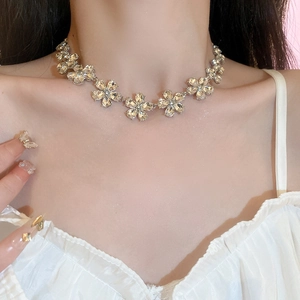 Model wearing silver flower necklace with sparkling crystals in a forest-style design
