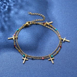 Detailed view of gold double-layer chain bracelet with cross charms and colorful beads