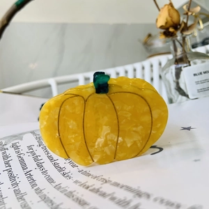 Macro shot of creative pumpkin hair claw clip with yellow marbled acetate texture