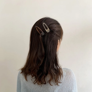 Minimalist resin hair clip set with tortoiseshell and transparent designs on wavy hair