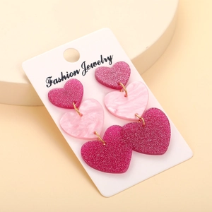 Pink glitter and marble acrylic heart drop earrings on white display card